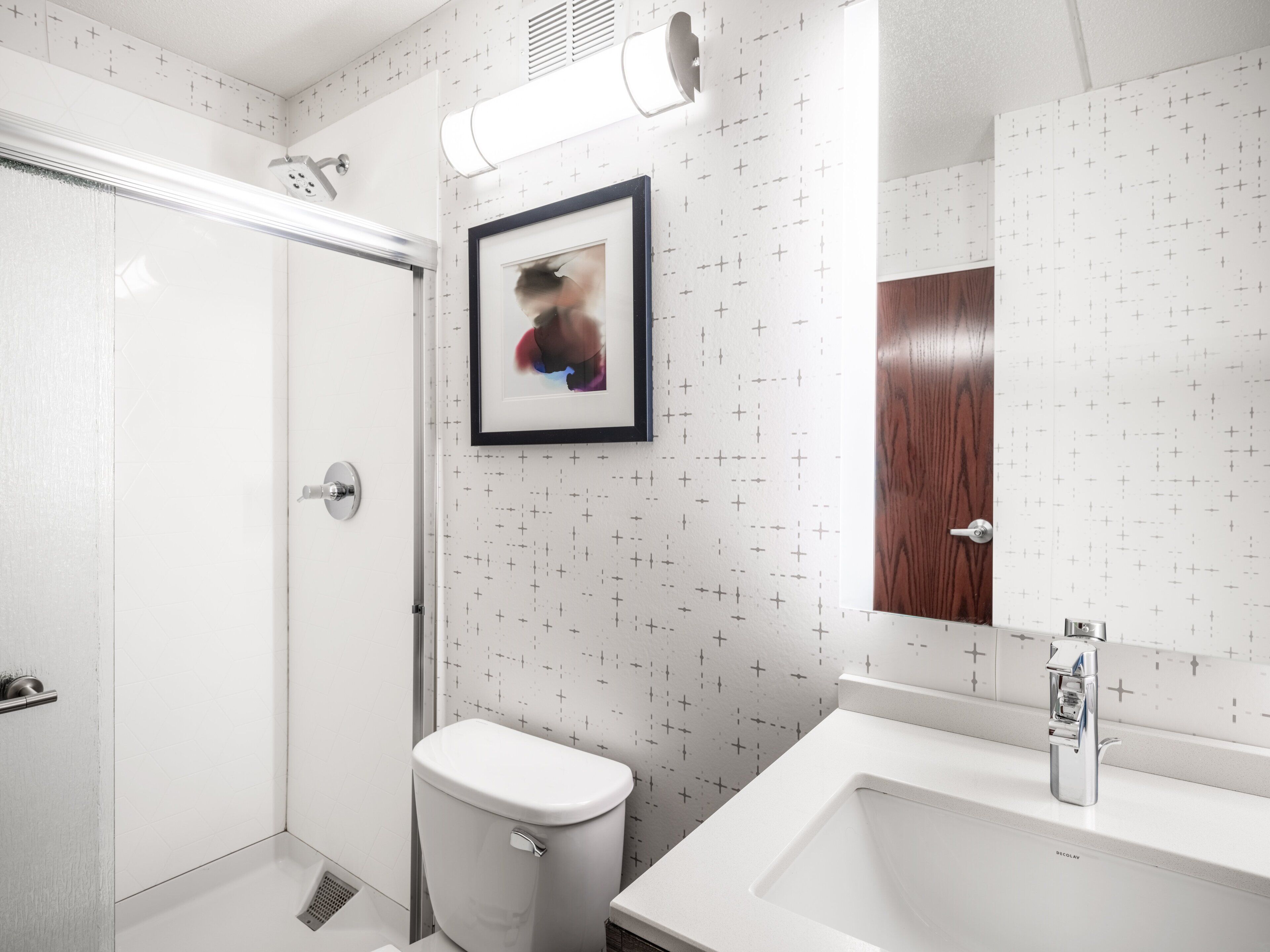 A modern bathroom with a toilet, sink, and shower.