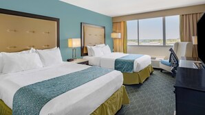 A hotel room with two beds, a desk, a chair, and a large window offering a view. - Wyndham Garden Kenosha Harborside (Kenosha)
