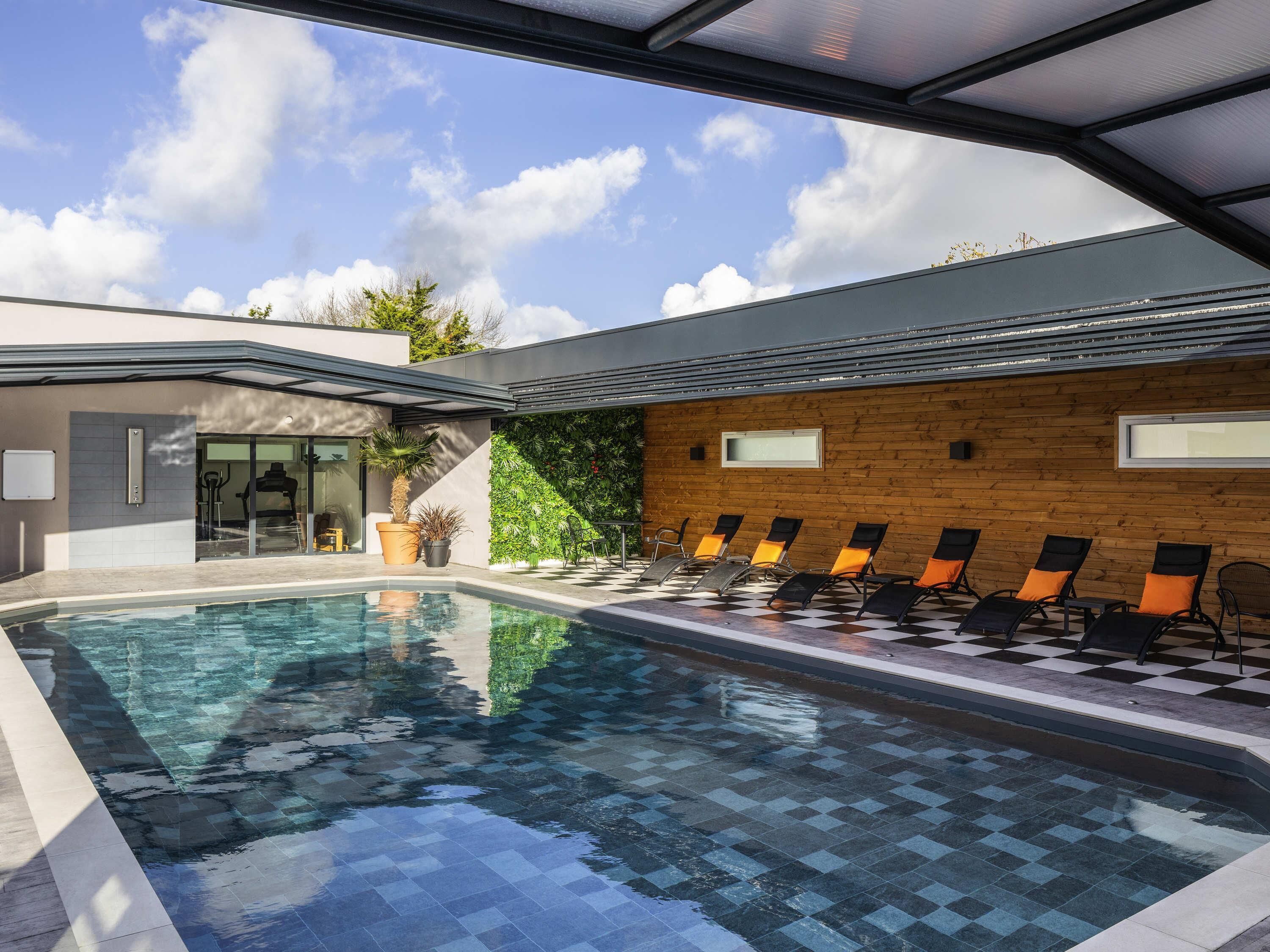 Una piscina techada, sillones reclinables de piscina