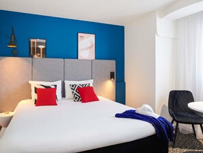 A hotel room with a bed, a desk, and a chair. - ibis Saint Nazaire Trignac (Trignac)