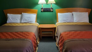 A hotel room with two beds, each with a headboard, a nightstand, and two wall-mounted lamps. - Emerald Inn & Lounge (Blythe)