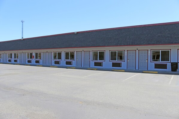 A long, single-story building with a flat roof and a series of windows along the side.