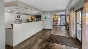 A hotel reception area with a reception desk, a television, and a sign indicating 'Quality by Choice Hotels'. - Quality Inn & Suites Easley - Greenville (Easley)