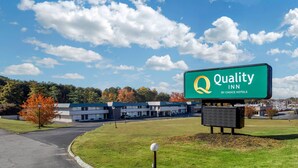 A Quality Inn by Choice Hotels with a clear sky and autumn foliage in the background. - Quality Inn & Suites Easley - Greenville (Easley)