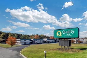 A Quality Inn by Choice Hotels with a clear sky and autumn foliage in the background. - Quality Inn & Suites Easley - Greenville (Easley)