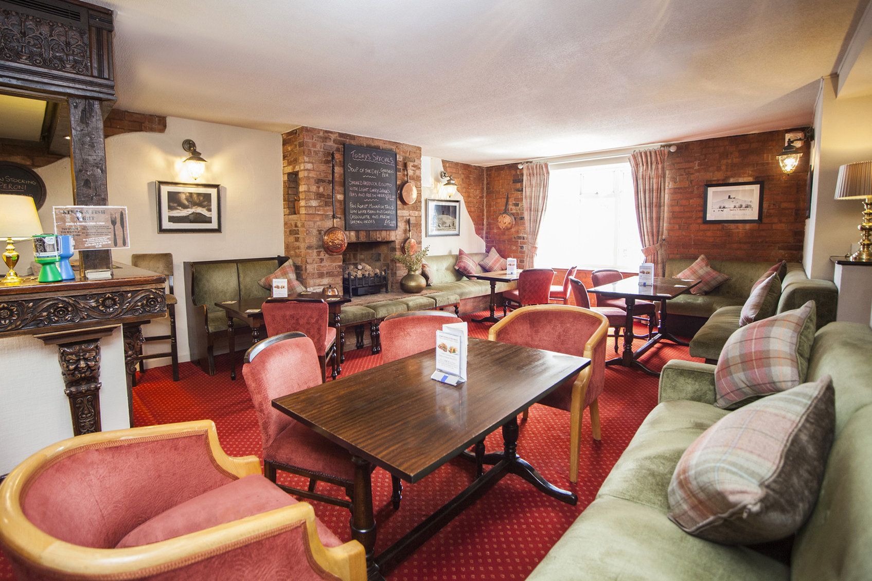 Ein gemütliches Restaurant mit Backsteinwänden, rotem Teppich und klassischer Einrichtung.