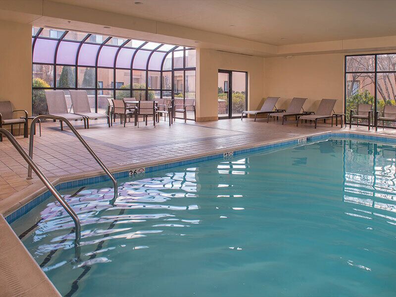 Una piscina techada, sillones reclinables de piscina