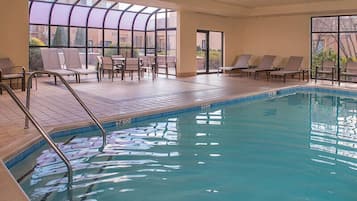 Una piscina techada, sillones reclinables de piscina
