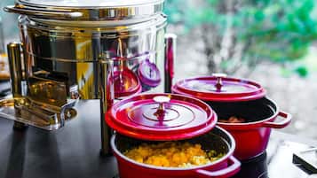 Una cocina con electrodomésticos de acero inoxidable y ollas rojas sobre una encimera.