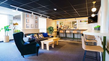 A modern interior with a bar area, seating, and a kitchen.