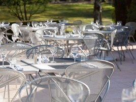 Outdoor dining tables with chairs, arranged in rows.