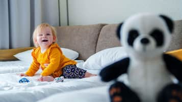 Un niño en una cama con un peluche de panda.