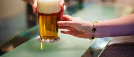 Una persona sosteniendo una cerveza en un bar.