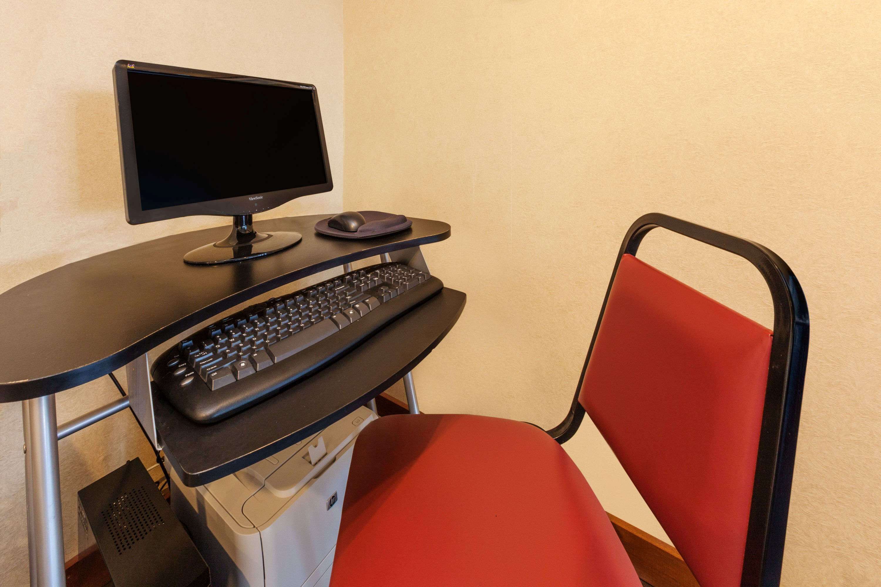 A desk with a computer setup, including a monitor, keyboard, and mouse.