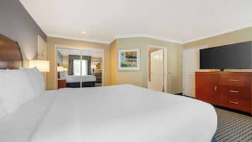 Habitación de hotel con una cama grande, televisión, escritorio con silla y armario.