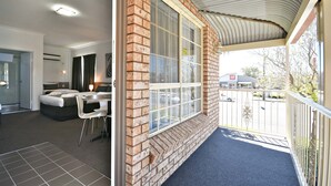 A hotel room with a large window, a balcony, and a view of the street. - The Aberdeen Motel (Dubbo)