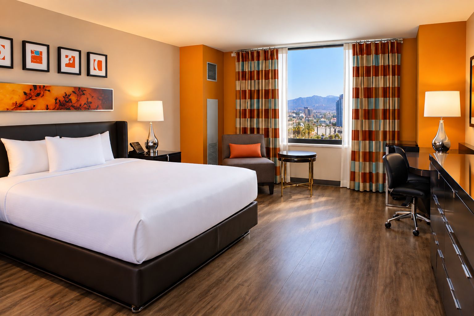 Habitación de hotel con una cama grande, un escritorio, una silla, una mesita y vistas a la ciudad.