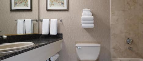 A bathroom with a sink, toilet, and bathtub. There are two framed pictures on the wall.
