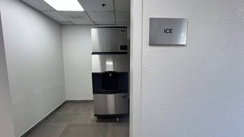 Un pasillo con un refrigerador de acero inoxidable y un dispensador de hielo en la pared.