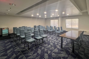 A conference room with rows of chairs, a table, and a vending machine. - Comfort Inn Jackson North - Ridgeland (Jackson)