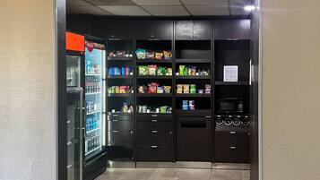 Espaço com máquina de venda automática, petiscos, bebidas e micro-ondas.