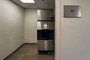 A corridor with a stainless steel refrigerator and a water dispenser, and a sign that reads 'ICE'. - Comfort Inn Jackson North - Ridgeland (Jackson)