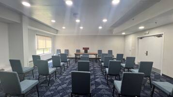 Sala de conferência com uma mesa comprida e várias cadeiras dispostas ao redor.