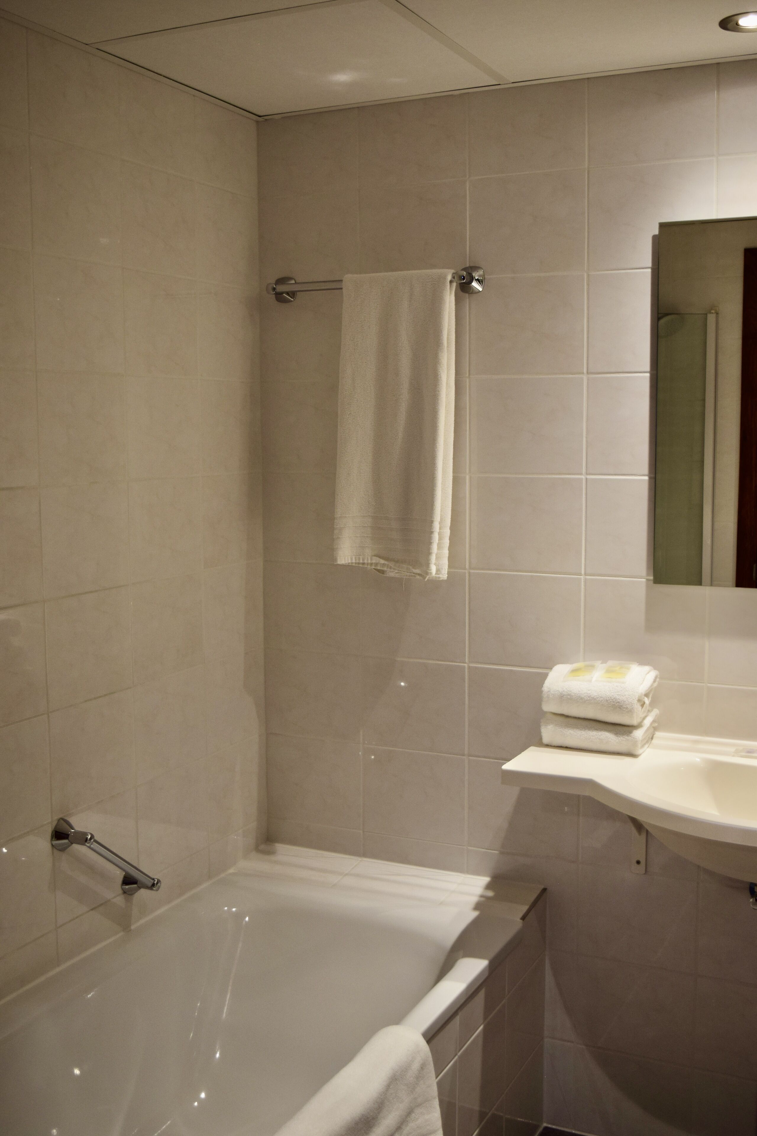 Une salle de bain avec une baignoire, un porte-serviettes et un lavabo.