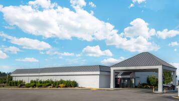 A building with a covered entrance and a parking lot.