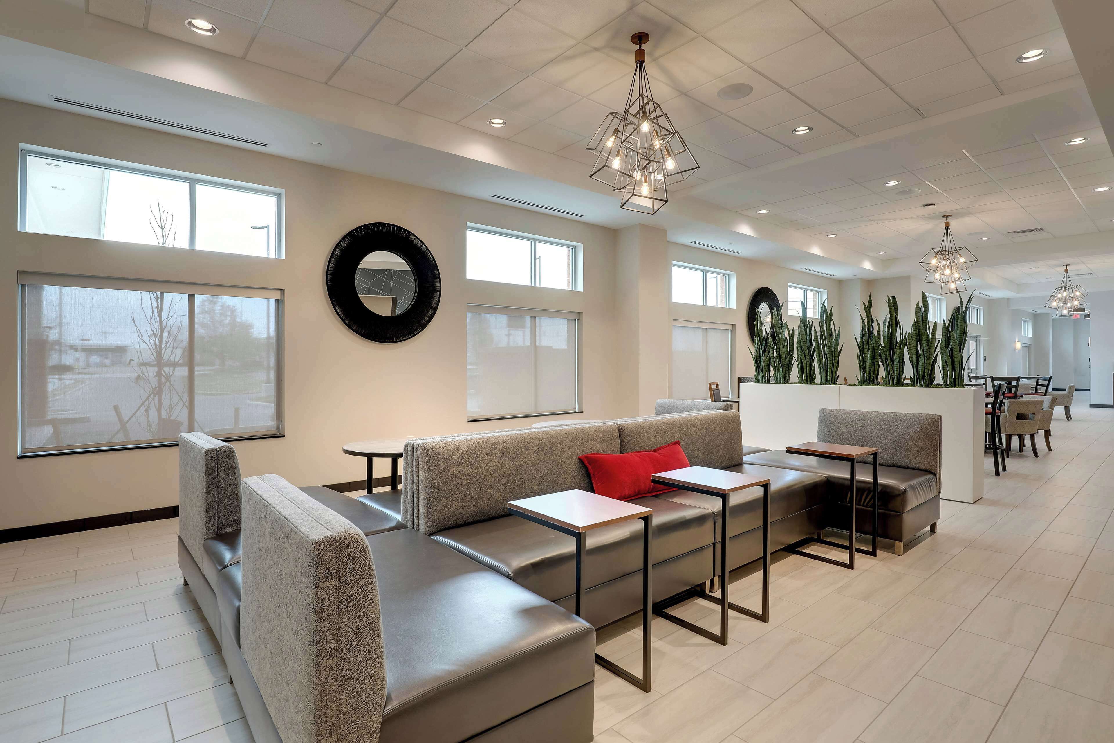 A modern lounge area with seating, tables, and large windows.