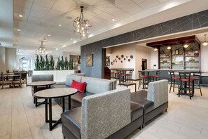 A modern interior with seating areas, tables, and a bar.