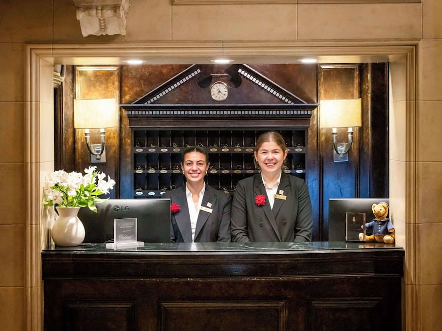 A reception desk with a clock, name tags, and a decorative vase.