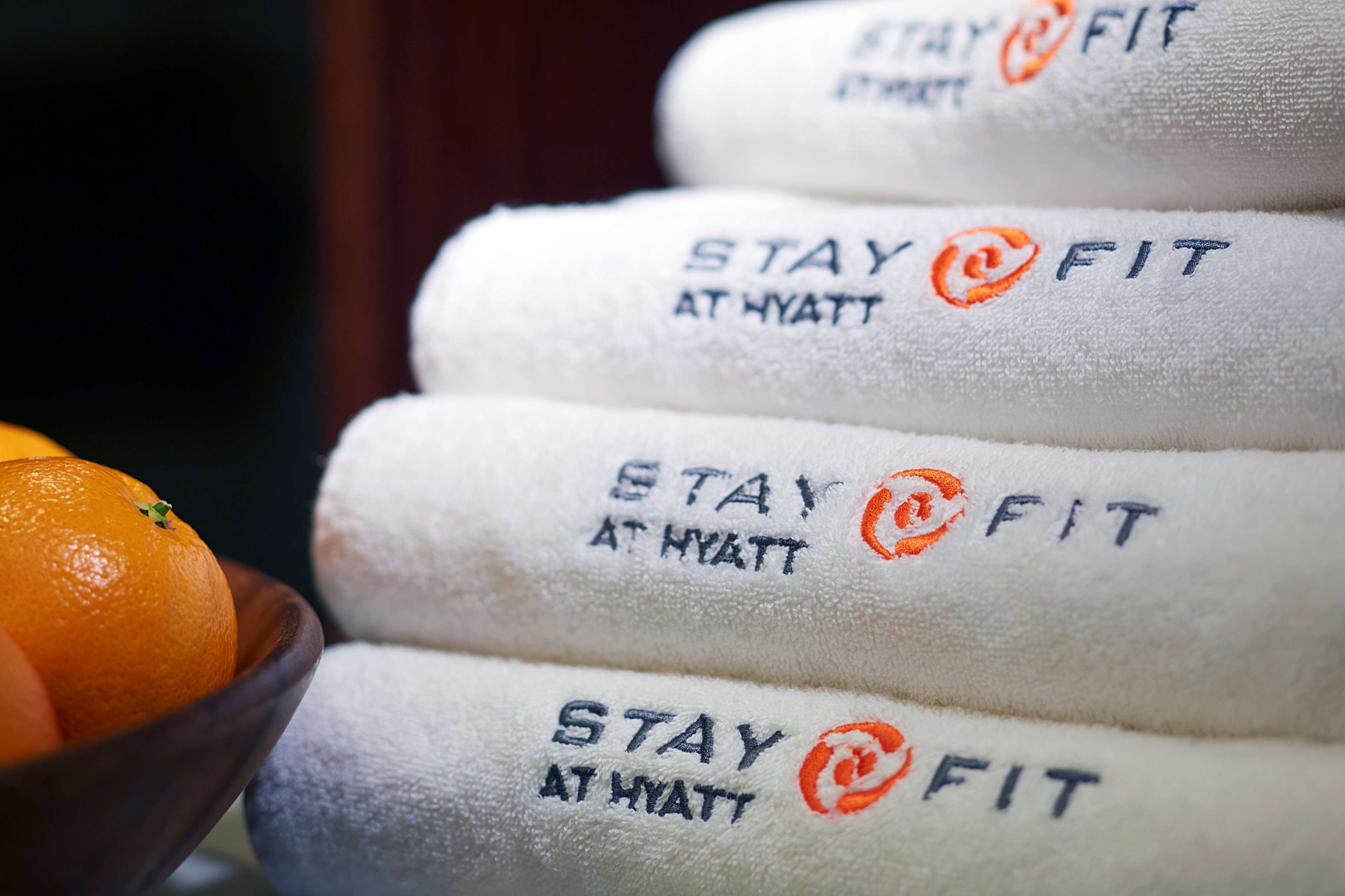 A stack of towels with the text "STAY @ FIT AT HYATT" printed on them.