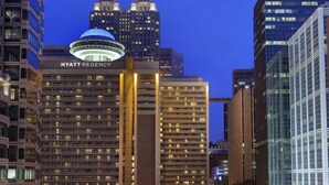 Un hôtel à plusieurs étages, reconnaissable à son enseigne bien visible indiquant « HYATT REGENCY ».