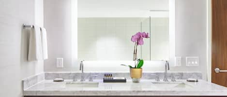 A modern bathroom with a large mirror, two sinks, and wooden cabinets.