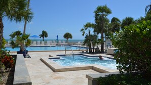 A pool area with multiple pools, lounge chairs, and palm trees. - 1800 Atlantic Suites (Key West)