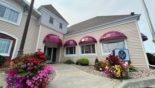 A two-story building with a sign indicating it is a pub and food & spirits. - Magnuson Grand Pioneer Inn and Suites (Escanaba)
