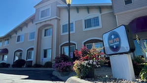 A hotel with a sign for "The Pub" and a Pioneer Inn & Suites logo. - Magnuson Grand Pioneer Inn and Suites (Escanaba)