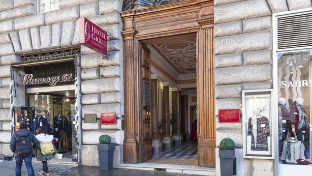 A hotel entrance with a checkered floor, a large arched window, and a sign for Hotel Gollin. - Hotel Giolli Nazionale (Rome)