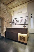 Una reception con una insegna con il numero '1880' e un'opera d'arte astratta incorniciata sopra.