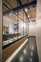 Una cucina moderna con un lungo bancone, pareti divisorie in vetro e diversi elettrodomestici.