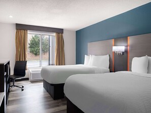 A hotel room with two beds, a desk, a chair, and a large window with curtains.