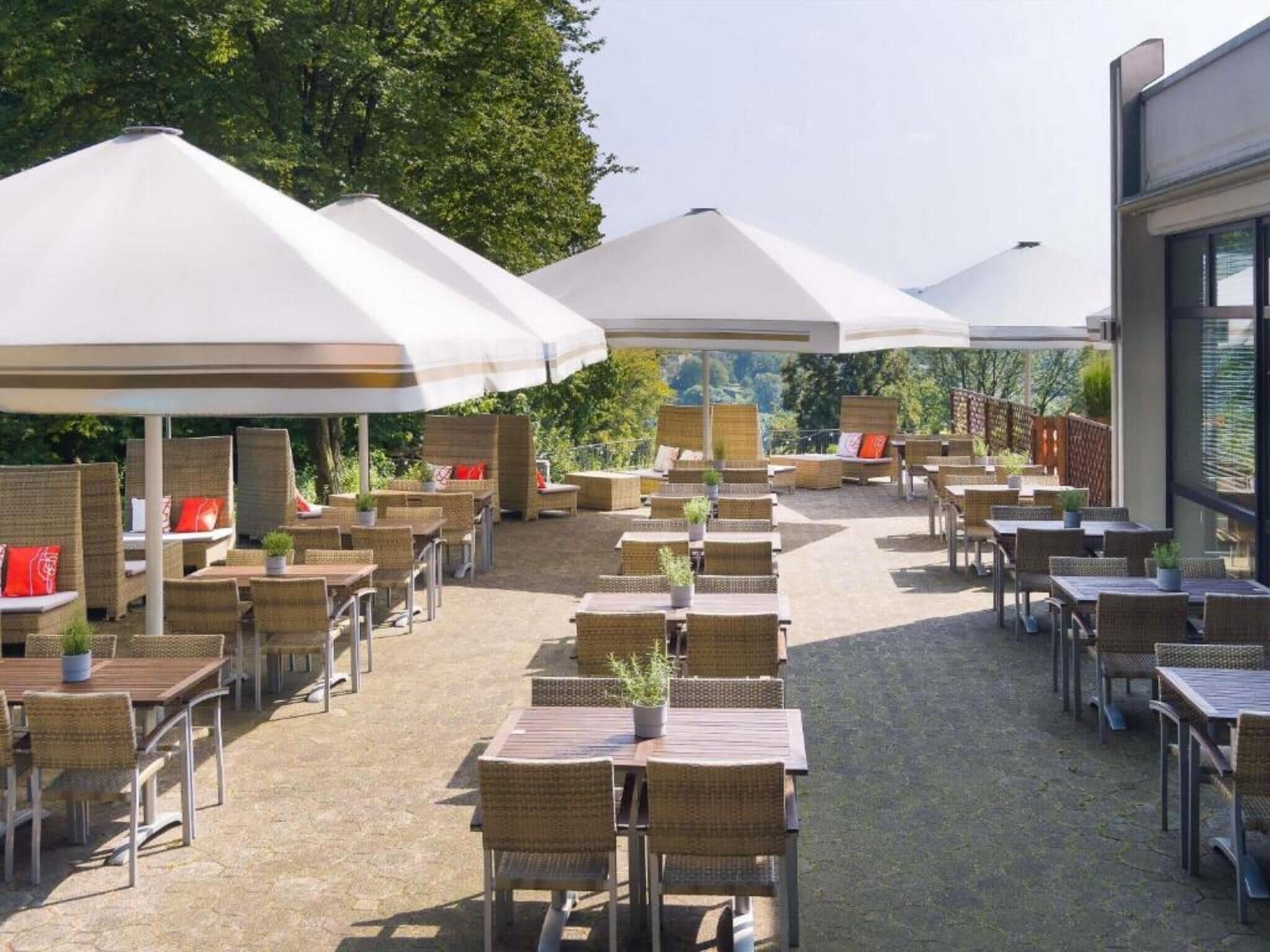 An outdoor patio with wicker furniture and white umbrellas.
