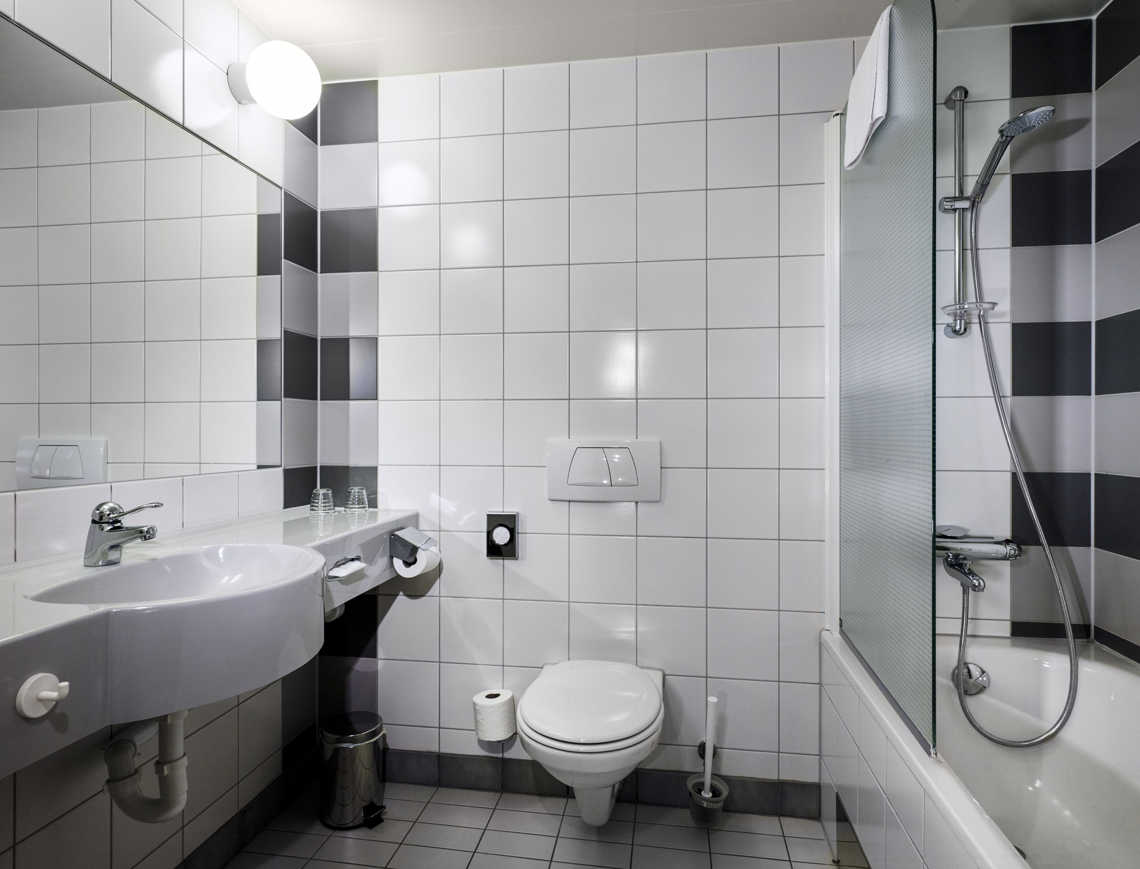Een moderne badkamer met een wit wastafel, toilet en douche.