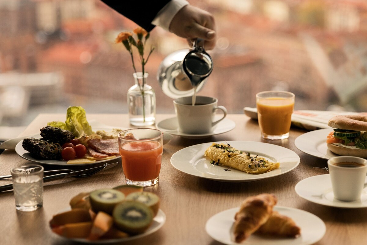 A breakfast table with various food items and beverages, including eggs, toast, and a muffin.