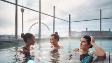 A pool area with large windows and a Ferris wheel in the background.