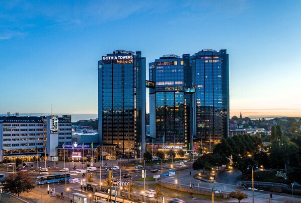 Kaupunkikuva, jossa on moderneja korkeita rakennuksia, kuten Gothia Towers -hotelli, sekä vilkas risteys, jossa liikkuu busseja ja autoja.