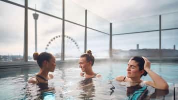 A pool area with large windows and a Ferris wheel in the background.