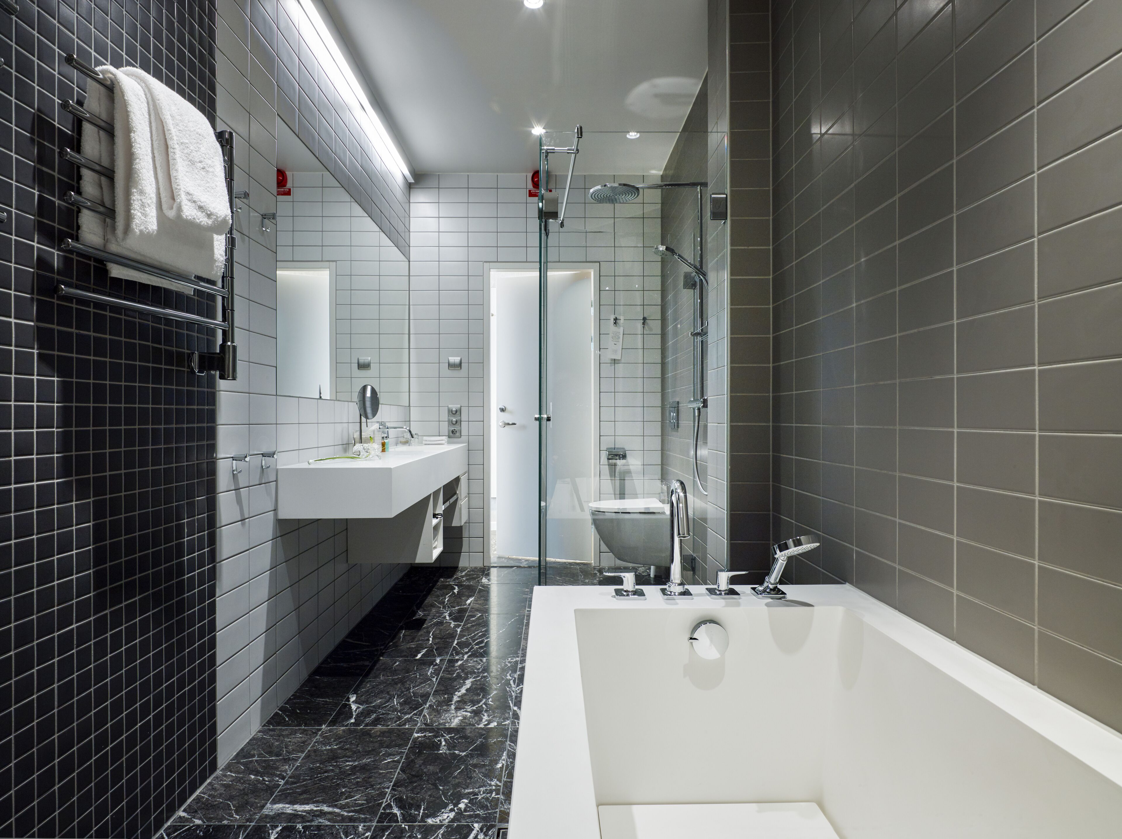 A modern bathroom with a large bathtub, a glass-enclosed shower, and a vanity with a mirror.