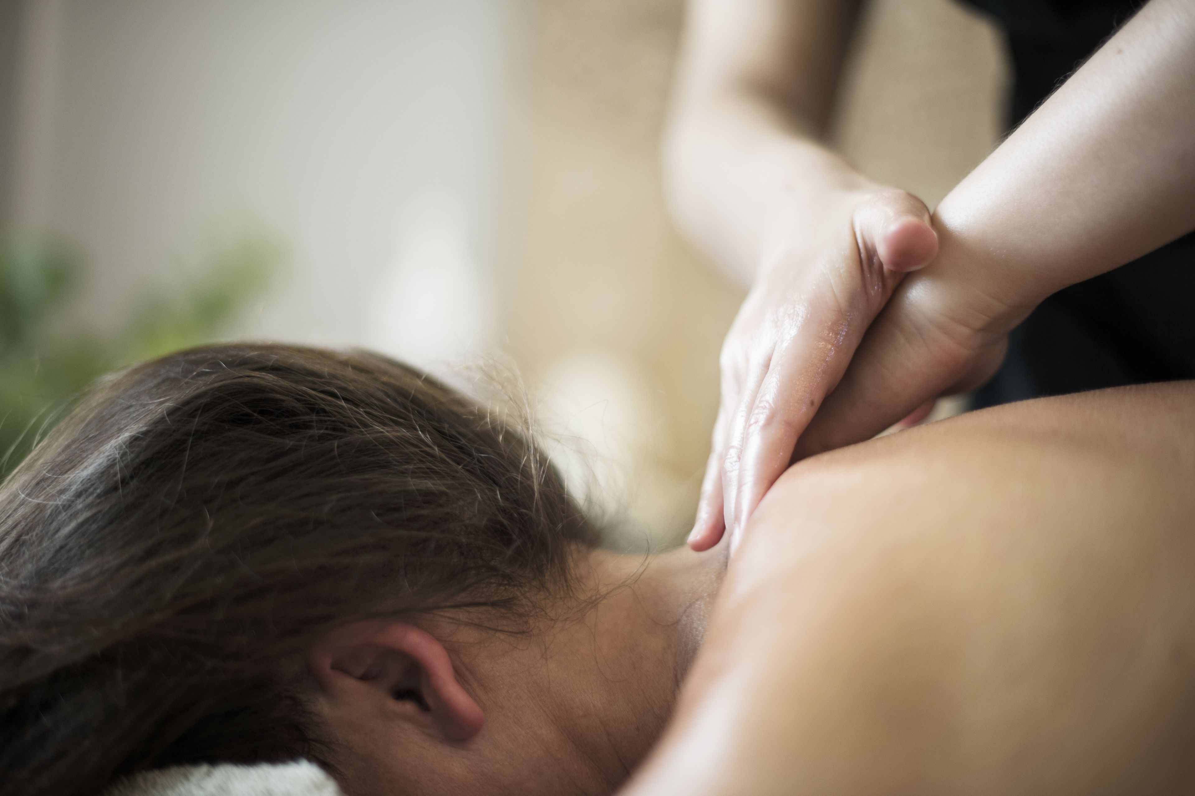 Gros plan d’un massage effectué sur le dos d’une personne.
